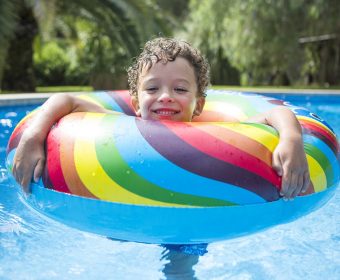 Criança feliz ao ficar em picisna no verão pós a limpeza da psicina